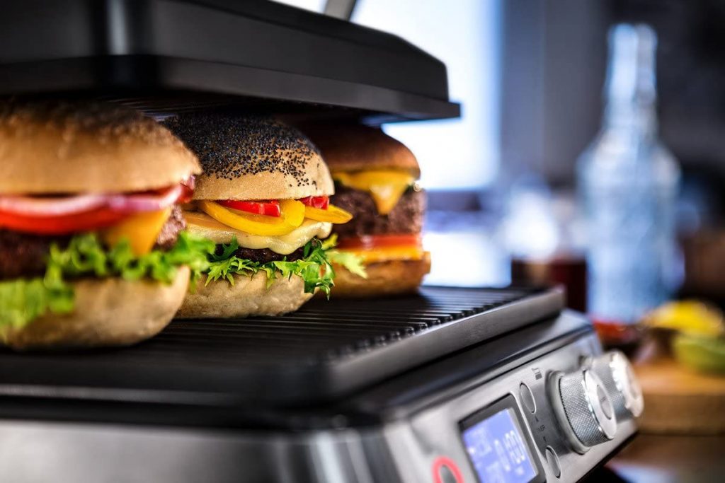 Des hamburgers qui sont en train de cuire à l'intérieur de la machine