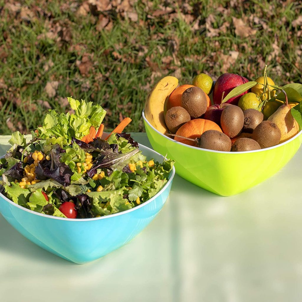 2 saladiers en plastique avec de la salade et des fruits